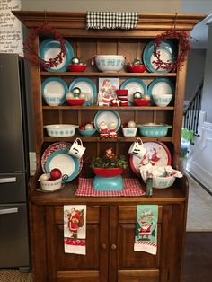 a wooden china cabinet with christmas dishes on it