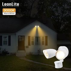 an image of two lights in front of a house at night with the light turned on