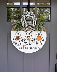 a door with a sign that says top the season and two penguins holding pumpkins