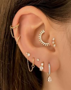 a woman's ear with three different types of piercings