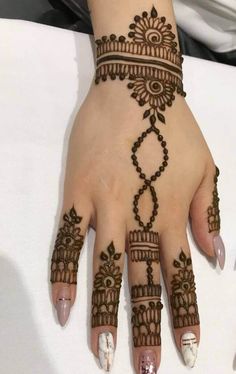 a woman's hand with henna tattoos on it