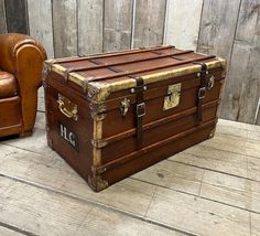 an old trunk sitting on the floor next to a chair