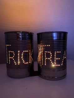 two tin canisters with lights that spell out the word irra on them