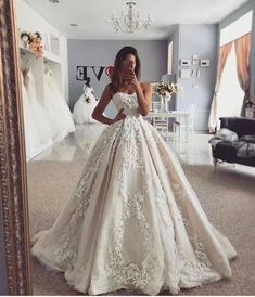 a woman in a wedding dress taking a selfie with her cell phone while standing in front of a mirror