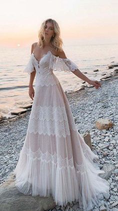 a woman in a white dress standing on the beach