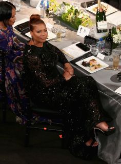 two women sitting at a table with food and drinks