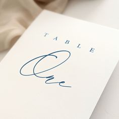 a close up of a piece of paper with a handwritten name on it and an object in the background