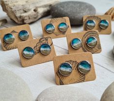 Introducing our real sand beach resin earrings, the perfect accessory for your summer wardrobe. Each tiny stud measures just 10mm and is handcrafted with real sand and resin waves, making each pair unique with its own wave pattern. Made with 316 stainless steel earring studs, these earrings are not only beautiful but also durable. Whether you're a beach lover yourself or looking for a special gift, these earrings are sure to make a statement. Each pair of earrings comes in a reusable drawstring Resin Waves, Beach Resin, Beach Jewellery, Ocean Earrings, Blossom Jewelry, Earrings Beach, Beach Lover Gifts, Beach Earrings, Market Stall