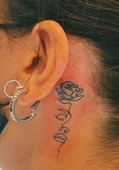 a woman with a tattoo on her neck and behind the ear that reads, love