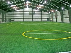 an indoor soccer field with yellow lines on the grass