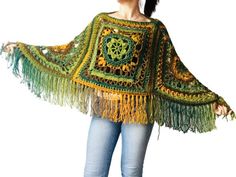 a woman wearing a green and yellow crocheted shawl with fringes on it