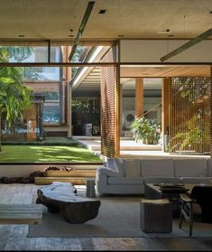 the living room is filled with furniture and large glass windows that look out onto an outdoor courtyard