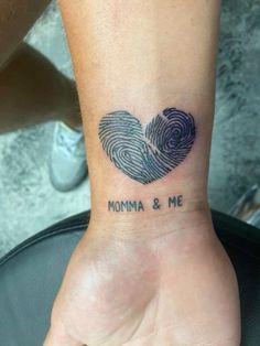 a woman's wrist with a fingerprint in the shape of a heart that says momma and me