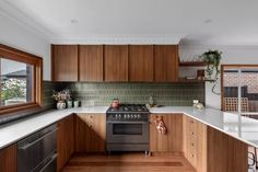 a kitchen with wooden cabinets and white counter tops, along with a stainless steel stove top oven