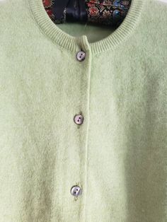 This is a vintage cardigan sweater. It is green, long sleeved and has Mother of Pearl buttons. I do not know its size as there is no label. Please refer to the measurements for a proper fit. I think this sweater is possibly lambswool or angora. I am not sure due to the missing label. Please note, there are 2 or 3 spots that are a bit dark. I dont think these are stains, just little dark marks in the fibers. They are evident in the 4th and 5th pictures. Please feel free to ask to see an image. Th Vintage Solid Color Winter Cardigan, Green Button-up Winter Cardigan, Vintage Cardigan For Winter, Green Buttoned Cardigan For Layering, Green Buttoned Sweater For Layering, Green Button-up Winter Sweater, Vintage Long Sleeve Cardigan For Layering, Vintage Style Long Sleeve Cardigan For Layering, Green Crew Neck Cardigan For Fall