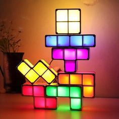 an illuminated rubik cube sitting on top of a table next to a potted plant