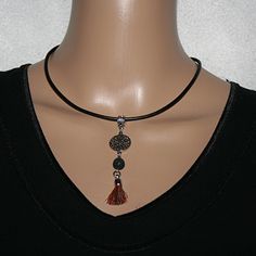 Cool leather necklace with pearls and a mandala pendant, lava bead and tassel. The leather necklace is 2mm wide, black and has a lobster clasp and extension chain.  This necklace is perfect for everyday wear and ideal as a gift for someone special. Spiritual Tassel Necklaces With Adjustable Fit, Adjustable Spiritual Tassel Necklaces, Black Necklace With Adjustable Cord For Meditation, Black Tassel Necklace With Adjustable Fit, Black Tassel Necklaces As Gift, Black Tassel Necklace Gift, Black Tassel Necklace As Gift, Mandala Pendant, Necklace With Pearls