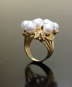 DeKara Designs Collection Beautiful Art Deco/Vintage/Modern Style Halo Diamond Pearl Cocktail Ring. Metal- 14K Yellow Gold, .583. Stones- Nine 6.5 MM Round Tahitian/South Sea Pearls, 20 Round Diamonds F-G Color SI2 Clarity 0.72 Carats. A handmade truly magnificent 14K Yellow Gold Pearl Diamond Ring. There is a beautiful cluster pearl ring with diamonds that are dazzling surrounding the pearls. This ring is perfect! The diamonds are stunning and make the pearls pop! You have a total of nine pearl Luxury White Cluster Pearl Ring, Vintage High Luster Rings For Anniversary, Antique Gold Pearl Ring For Wedding, Elegant Handmade Round Diamond Ring, Handmade Gold Diamond Ring Elegant Style, Elegant Handmade Diamond Ring, Handmade Diamond Rings For Formal Occasions, Handmade Elegant Round Diamond Ring, Vintage High Luster Jewelry For Anniversary