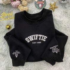 Celebrate your music and nostalgia with the Swiftie Era Sweatshirt, a garment that's not just cozy but also a statement of fandom. Perfect for those chilly evenings or casual outings, this sweatshirt is a tribute to a musical journey that spans decades. Size: Available from S to XXXL, accommodating a full range of body sizes for a comfortable fit. Material: Made with a high-quality cotton blend, it ensures both softness and durability for long-lasting wear. Intended Age Range: While designed with fans in mind, its age-neutral appeal makes it suitable for a wide range of ages, from teens to adults. Special Features: The sweatshirt proudly displays iconic album titles along the sleeves, creating a timeline of musical eras. Technical Specifications: Features a ribbed neck, cuffs, and hem for Create A Timeline, Explore The World, Sporty Look, Your Music, Body Size, Special Features, Mens Sweatshirts, Looks Great, Everyday Wear