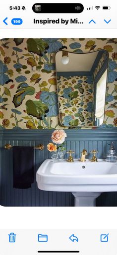 the bathroom is decorated in blue and green with flowers on the wall next to the sink