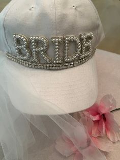 Make the Bride feel extra special with this white adjustable BRIDE Hat/Cap with attached veil. BRIDE hat is adorned with pearled letters with rhinestone trim for added sparkle! Great for Bridal Showers and Bachelorette Parties! Please visit our store for other Special Wedding Keepsakes. Thank you everyone!! Wishing you a Beautiful Wedding Day! Best Always, Elegance by Gianna Adjustable Bridal Accessories With Rhinestones, Adjustable Rhinestone Bridal Accessories, Adjustable Rhinestone Bridal Accessories For Wedding, Adjustable White Bridal Accessories For Bridal Shower, Bride Hat, Rhinestone Trim, Bachelorette Parties, Wedding Keepsakes, Bridal Showers