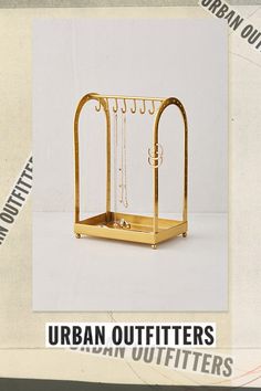 an image of a golden metal rack with chains hanging from it's sides and the words urban outfitters written below