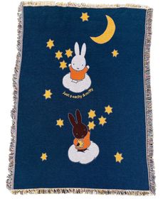 a blanket with two rabbits on it and the moon in the sky above them,