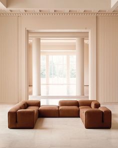 a large couch sitting in the middle of a room with columns on either side of it