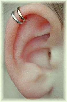 a close up of a person's ear with two rings on top of it