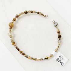 Dainty beads in gold and bronze strung on a steel wire in a cuff shape. Beaded Cuff, Beaded Bracelets, Cuff, Beads, Gold