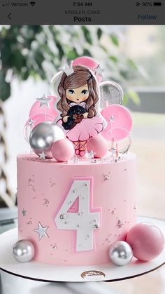 a pink birthday cake with a doll on top