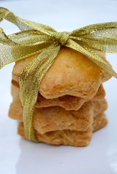 a stack of cookies with a gold ribbon tied around the top on a white plate