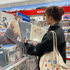 a woman looking at cds in a store