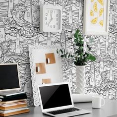 an open laptop computer sitting on top of a desk next to a clock and plant