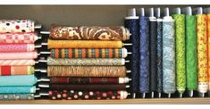 a book shelf filled with lots of different colored fabrics