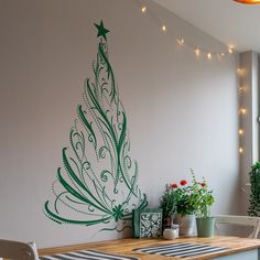 a christmas tree painted on the wall next to a table