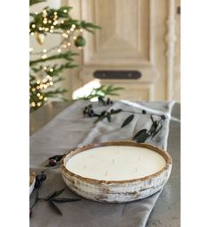 a wooden bowl sitting on top of a table next to a christmas tree in the background