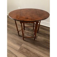 a round wooden table sitting on top of a hard wood floor