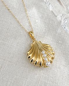 The Shell Locket Necklace with faux pearls. Perfect for the romantic beach get away or beach wedding. An elegant gold plated silver shell 20mm with shell pearls and delicate gold filled chain. All items come in a gift box ready to gift. To see more please visit  https://www.etsy.com/shop/BijouLimon Bijou Limon jewelry collections present a romantic French spin on the latest jewelry trends. Based on the US West Coast but French at heart, Bijou Limon interprets the current jewelry trends and delivers timeless pieces that make you swoon. From Necklaces, Earrings, Bracelets, Rings and more, our Collections are filled with pieces that are both new and nostalgic. Find your unique accessories to complete your look. Personal Insight  What sets me apart? As a small business owner, I'm very consciou Gold Sea Shell Necklace, Venus Aphrodite, Shell Locket, Gold Locket Necklace, Pearl Birthstone, Latest Jewellery Trends, Romantic Beach, Unique Accessories, Seashell Necklace