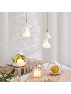 three clear glass globes with candles inside