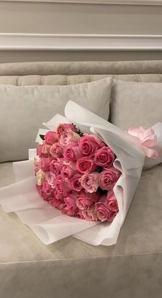 a bouquet of pink roses sitting on top of a couch