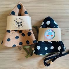 two black and white polka dot bags on a wooden table with a thank you tag