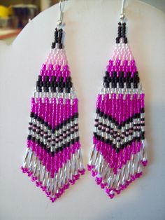 pink and black beaded earrings hanging from a hook