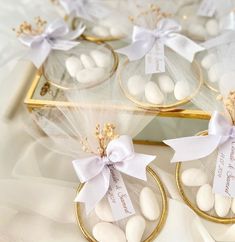 white candies in small gold baskets with ribbons on them and tags attached to them