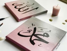 two pink and silver books with arabic writing on them