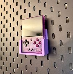 a pink and purple device mounted to a metal wall with holes on it's sides