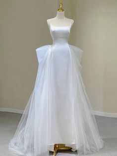 a white wedding dress on display in a room