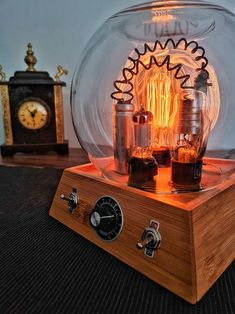 an old fashioned light bulb sitting on top of a wooden stand next to a clock