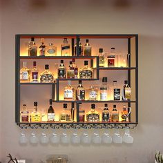 a wall mounted shelf filled with lots of bottles and glasses on top of a counter