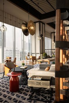 a living room filled with lots of furniture and tall windows next to a large window